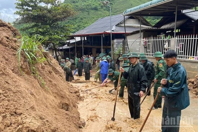 Bộ đội Biên phòng vùng thượng du Thanh Hóa xử lý đất, đá sạt từ ta luy xuống đường dân sinh. (Ảnh: Báo Nhân Dân)
