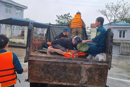 Lực lượng chức năng xã Điện Bàn Tây vận chuyển người bị nạn qua vùng ngập lũ để đi cấp cứu.