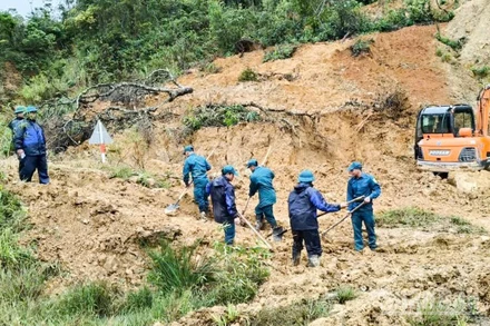 Lực lượng dân quân tự vệ xã Hùng Sơn khẩn trương dọn đất đá để khơi thông đường.