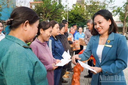 Chủ tịch Ủy ban Mặt trận Tổ quốc Việt Nam phường Hương Trà Nguyễn Thị Thao trao quà cho các hộ có hoàn cảnh khó khăn bị ảnh hưởng bởi thiên tai.