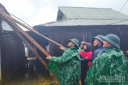 Các lực lượng chức năng hỗ trợ người dân xã Hùng Sơn lợp lại mái nhà bị tốc.