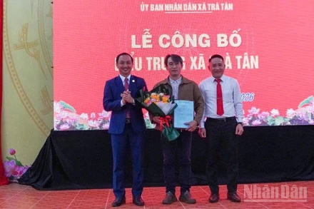 Lãnh đạo xã Trà Tân tặng hoa cho tác giả thiết kế biểu trưng xã Trà Tân.