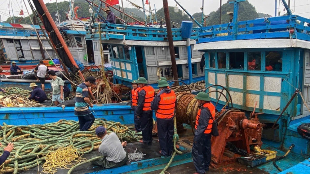 Cán bộ, chiến sĩ Hải đoàn Biên phòng 38 hướng dẫn ngư dân chằng buộc tàu thuyền, kiểm tra dây, phao, thu dọn lưới, ngư cụ. (Ảnh: HÀ VINH) z6826835194857-2047e3e72b06af4f21831f4ed72a9a1d-8467.jpg