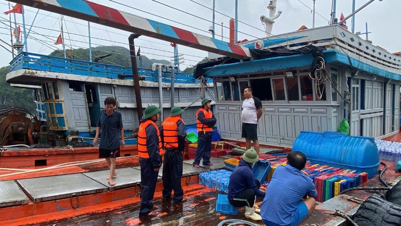 Cán bộ, chiến sĩ Hải đoàn Biên phòng 38 vận động người dân gia cố, chằng buộc phương tiện tránh, trú bão. (Ảnh: HÀ VINH)