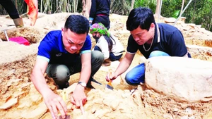 Chuyên gia khảo cổ và cán bộ Bảo tàng tỉnh Hà Giang xử lý di tích xuất lộ.