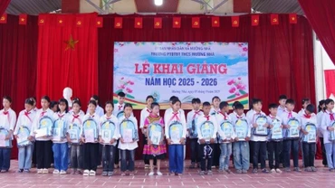 Cán bộ Đồn Biên phòng Cửa khẩu Huổi Puốc và Mường Nhà tặng quà tặng học sinh trong Dự án “Cán bộ, chiến sĩ Quân đội nâng bước em tới trường”. (Ảnh: ANH DŨNG)