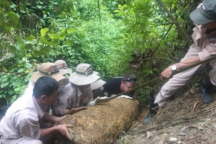 Đội xử lý lưu động của MAG kéo, vận chuyển quả bom ở lưng chừng bờ suối đến khu vực chờ hủy nổ tập trung
