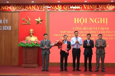 Bí thư Tỉnh ủy Quảng Bình Lê Ngọc Quang (áo xanh) trao quyết định cho Ban biên tập Báo và Đài Phát thanh - Truyền hình Quảng Bình. 