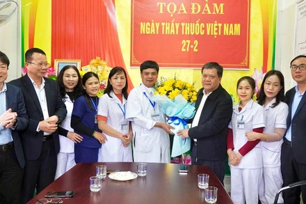 Chủ tịch Ủy ban nhân dân tỉnh Quảng Bình Trần Phong tặng hoa chúc mừng các cán bộ, y, bác sĩ Trạm Y tế xã Thượng Trạch. (Ảnh: TA)