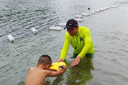 Kỹ thuật viên của Công ty du lịch Chua me đất dạy bơi cho trẻ em ở thị trấn Phong Nha, Quảng Bình. (Ảnh HƯƠNG GIANG) 