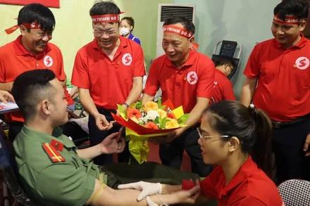 Phó Bí Thư Thường trực Tỉnh ủy Quảng Bình Trần Hải Châu tặng hoa cho tình nguyện viên hiến máu cứu người (Ảnh: DH)