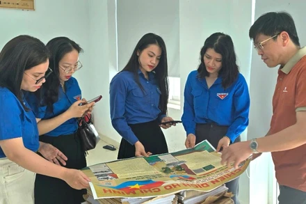 Các đoàn viên thanh niên tỉnh Quảng Bình hào hứng với phụ san đặc biệt của Báo Nhân Dân.