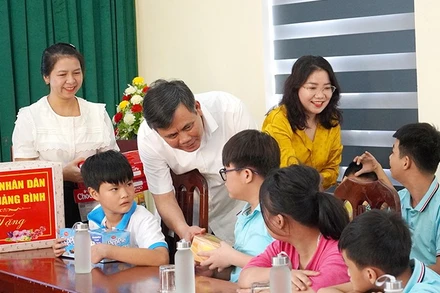 Chủ tịch tỉnh Quảng Bình Trần Thắng trao quà cho các em khuyết tật tại Trung tâm nuôi dạy trẻ khuyết tật thành phố Đồng Hới (Ảnh: AT)
