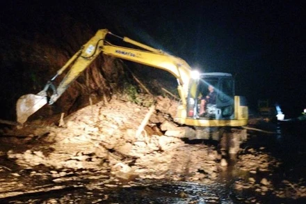 Lực lượng chức năng xử lý điểm sạt lở, đất đá ra mặt đường trên quốc lộ 12A trong đêm để thông đường.