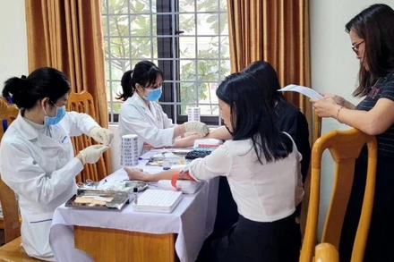 Nhân viên MEDLATEC Quảng Bình lấy mẫu xét nghiệm cho giáo viên một trường trung học phổ thông ở thành phố Đồng Hới.