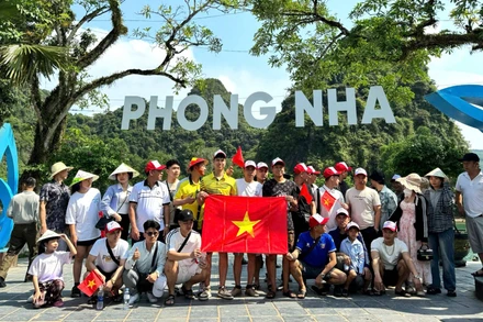 Du khách chụp ảnh lưu niệm trước khi xuống thuyền tham quan động Phong Nha và động Tiên Sơn.