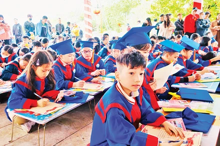 Học sinh Hải Phòng khai bút tại Khu tưởng niệm Vương triều Mạc. (Ảnh HỒNG NHUNG)