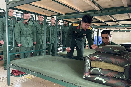 Chỉ huy Đại đội 8, Tiểu đoàn 2, Trung đoàn 2, Sư đoàn 395 (Quân khu 3) hướng dẫn chiến sĩ mới cách gấp chăn, màn.