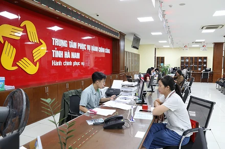 Cán bộ, công chức Trung tâm hành chính công tỉnh Hà Nam giải quyết thủ tục hành chính cho người dân.