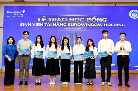 Đại diện Trường đại học Kinh tế quốc dân trao học bổng sinh viên xuất sắc. (Ảnh PHƯƠNG LINH)