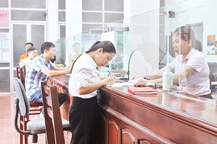 Nhân viên Ngân hàng Chính sách xã hội thị xã Duy Tiên giải ngân cho khách hàng vay để mua nhà ở xã hội.