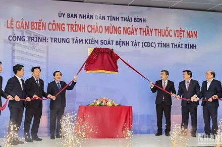 Các đại biểu thực hiện nghi thức gắn biển công trình chào mừng Ngày Thầy thuốc Việt Nam cho tòa nhà CDC Thái Bình.