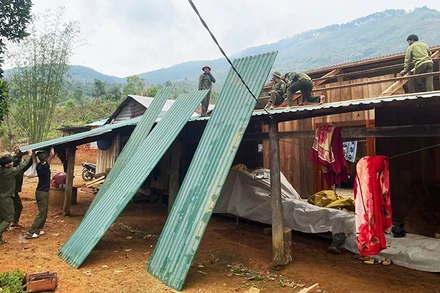 Lực lượng dân quân tự vệ và thanh niên hỗ trợ người dân sửa chữa lại nhà cửa.
