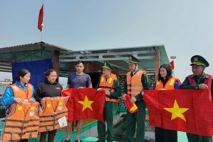 Đồn Biên phòng Cô Tô và Đoàn thanh niên thị trấn Cô Tô tặng cờ Tổ quốc và áo phao cho ngư dân.