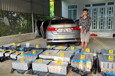 Đối tượng Huỳnh Văn Bổn cùng tang vật thuốc lá nhập lậu.