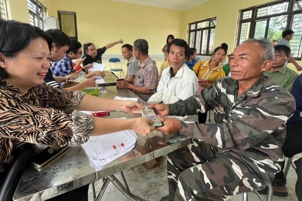 Cán bộ Công ty Cổ phần Cao-su Điện Biên chi trả tiền góp đất cho các hộ dân trên địa bàn huyện Mường Chà.