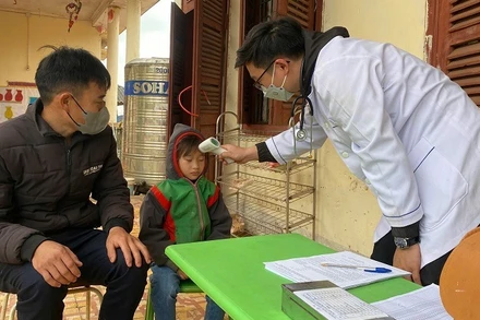 Cán bộ Trung tâm Y tế huyện Nậm Pồ khám sàng lọc trước lúc tiêm vaccine phòng bệnh sởi cho trẻ em trên địa bàn huyện. 
