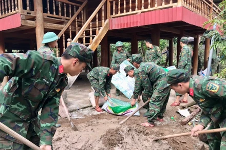 Cán bộ, chiến sĩ Tiểu đoàn 1, Trung đoàn 741 giúp người dân xã Mường Toong, huyện Mường Nhé sửa nhà.