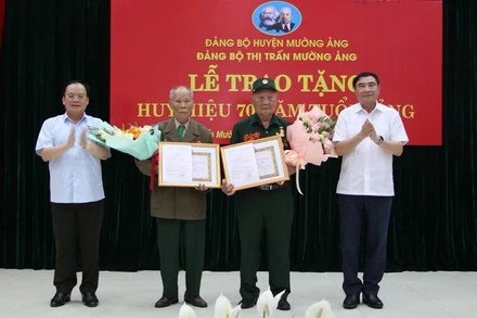 Đồng chí Trần Quốc Cường, Bí thư Tỉnh ủy Điện Biên và đồng chí Mùa A Sơn, Phó Bí thư Thường trực Tỉnh ủy Điện Biên tặng hoa, chúc mừng 2 chiến sĩ Điện Biên vinh dự được nhận Huy hiệu 70 năm tuổi Đảng.
