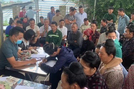 Cán bộ Công ty Cổ phần Cao su Điện Biên chi trả tiền góp đất cho người dân xã Mường Pồn (huyện Điện Biên).