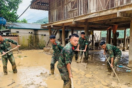 Chiến sĩ các đơn vị thuộc Bộ Chỉ huy quân sự tỉnh Điện Biên giúp người dân xã Mường Pồn thu dọn nhà cửa, dọn dẹp vệ sinh ổn định cuộc sống sau lũ quét. 