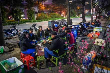 [Ảnh] Ấm cúng bữa cơm tiễn năm cũ bên vỉa hè 