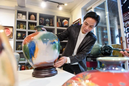 Nghệ nhân ưu tú Trần Đức Tân bên sản phẩm gốm dòng men Suối Ngọc.