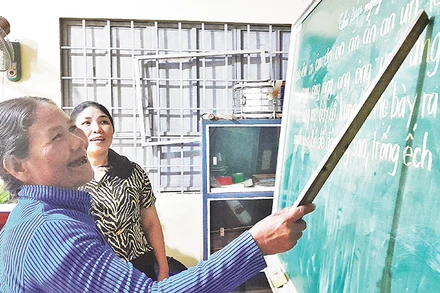 Học sinh lớn tuổi tại lớp học xóa mù chữ tại thôn 6 (xã Long Tân) đang tập đọc.