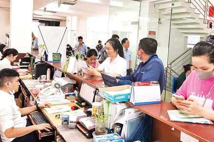 Thành phố sẽ thực hiện chính sách chi thu nhập tăng thêm nhằm tạo động lực cho cán bộ, công chức, viên chức và người lao động. Trong ảnh: Cán bộ cơ quan Bảo hiểm xã hội thành phố tiếp nhận hồ sơ của người lao động.