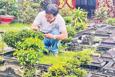 Anh Nguyễn Thanh Tùng chăm chút từng góc nhỏ trong công trình “Cố đô Huế thu nhỏ”.