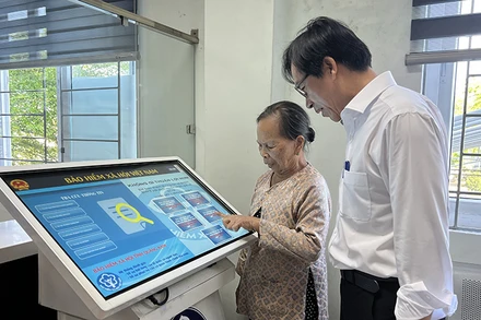 Cán bộ Bảo hiểm xã hội thành phố Hội An, tỉnh Quảng Nam hướng dẫn người dân làm thủ tục bảo hiểm xã hội.