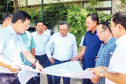 Chủ tịch UBND thành phố Hà Nội Trần Sỹ Thanh (đứng giữa) kiểm tra thực tế tại ô đất xây dựng trường học thuộc khu chức năng đô thị Ao Sào, Thịnh Liệt, quận Hoàng Mai. (Ảnh THỦY TIÊN)