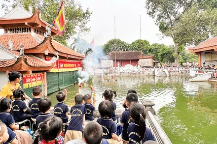 Các em nhỏ hào hứng xem các tiết mục rối nước tại làng rối Đào Thục.