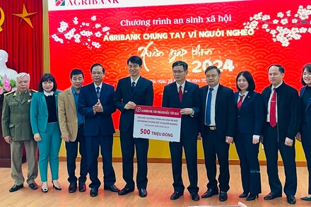 Giám đốc chi nhánh Agribank Bắc Yên Bái trao biểu trưng 500 triệu đồng cho người nghèo tỉnh Yên Bái. (Ảnh: THANH SƠN)