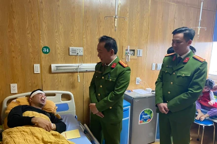 Đại tá Nguyễn Xuân Tuấn cùng lãnh đạo công an thành phố Yên Bái thăm, động viên Thượng úy Trần Trung Đức tại khoa Chấn thương. (Ảnh: THANH SƠN)