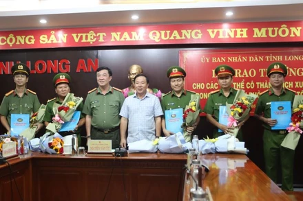 Chủ tịch Ủy ban nhân dân tỉnh Long An Nguyễn Văn Út và Giám đốc Công an tỉnh Long An Lâm Minh Hồng trao thưởng cho lực lượng phá án nhanh. 