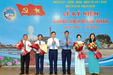 Đại diện lãnh đạo tỉnh Bình Thuận trao Bằng khen của Chủ tịch Ủy ban nhân dân tỉnh và tặng hoa chúc mừng cán bộ, nhân dân huyện Hàm Thuận Nam.