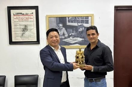 Đồng chí Quế Đình Nguyên, Phó Tổng Biên tập Báo Nhân Dân trao quà lưu niệm Phó Tổng Biên tập báo Gramma.