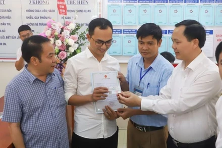 Anh Đinh Tiến Hoàng (huyện Thanh Liêm, Hà Nam) nhận giấy khai sinh và thẻ bảo hiểm y tế cho con gái mới sinh, sau khi làm thủ tục hành chính liên thông.