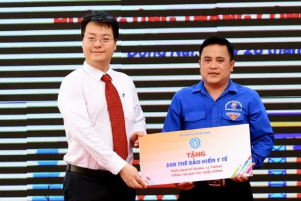 Đại diện Bảo hiểm Xã hội Việt Nam trao bảng biểu trưng 300 thẻ bảo hiểm y tế cho Tỉnh đoàn Đồng Nai.